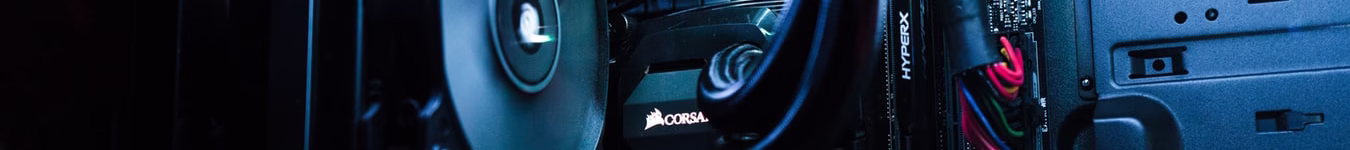 صورة داخل حاسوب مكتبي تظهر بطاقة رسوميات Corsair ولوحة أم HyperX مع أسلاك ملونة وإضاءة زرقاء تبرز التفاصيل الدقيقة للمكونات. البتول ستور